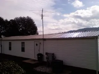 New metal roof on a single wide mobile home with a TV antenna in Hannaford