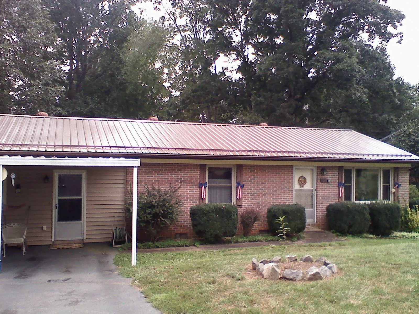 Bronze metal roof and carport on a brick ranch home — Roof Repair work by our crew in Hannaford